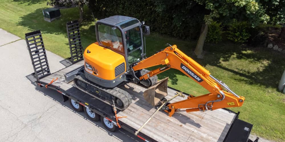 Doosan mini excavator being hauled on a trailer